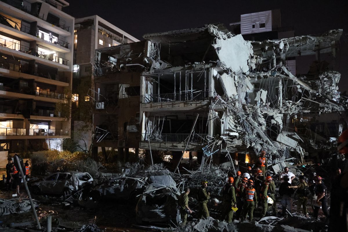 Israeli troops and first responders gather in front of a building hit by a missile fired from Iran, in Ramat Gan near Tel Aviv on June 13, 2025. Iran fired a barrage of ballistic missiles at Israel in a counter-strike in the evening on June 13, after an unprecedented onslaught hammered the Islamic republic's top military brass and targeted its nuclear facilities and bases. (Photo by Jack GUEZ / AFP)