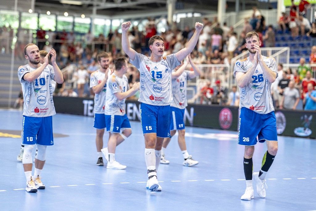 Essen, kézilabda, német, Bundesliga 2., újrajátszás, Dessau-Rosslauer, 29 June 2025, North Rhine-Westphalia, Essen: Handball: 2nd Bundesliga, TuSEM Essen - Dessau-Roßlauer HV, 29th matchday, Sporthalle Am Hallo: Dessau-Roßlauers Vincent Bülow (l-r), Dessau-Roßlauers Marcel Nowak and Dessau-Roßlauers Yannick Danneberg celebrate after the victory and the relegation. Photo: David Inderlied/dpa (Photo by David Inderlied / dpa Picture-Alliance via AFP)