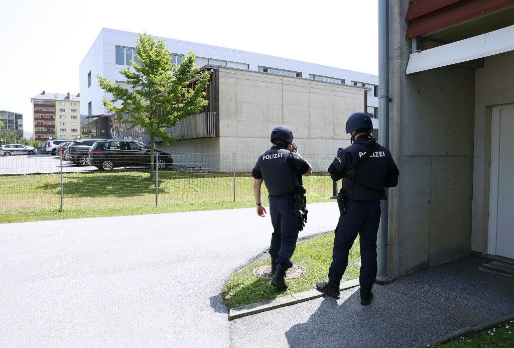 Two policemen are seen close to a school where, according to reports, several people died in a shooting, on June 10, 2025 in Graz, southeastern Austria. Several people died in a school shooting, including the attacker, Austrian broadcaster ORF quoted the interior ministry as saying. (Photo by ERWIN SCHERIAU / APA / AFP) / Austria OUT