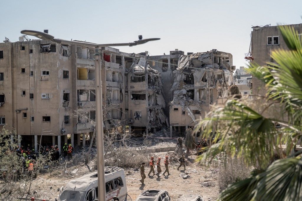 Israeli armed forces members survey damaged buildings in Holon, Israel, on June 19, 2025, after an Iranian ballistic missile strike left multiple Israelis wounded, some critically. (Photo by Dima Vazinovich / Middle East Images via AFP)
