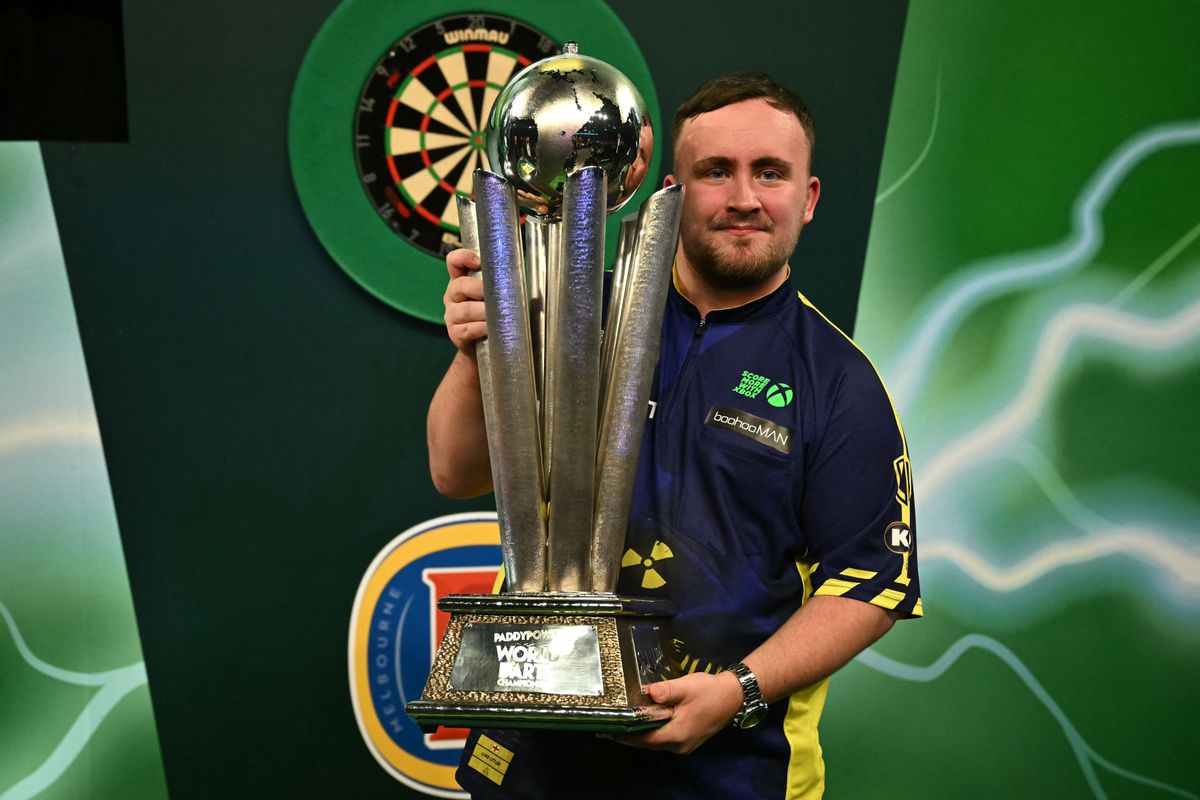 Luke Littler a PDC-dartsvilágbajnokság trófeájával, idén magyar dartsversenyző is harcba száll vele
