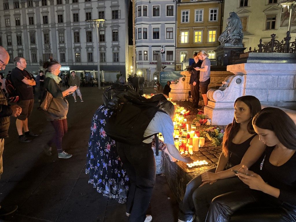 GRAZ, AUSTRIA - JUNE 10: People light candles to commemorate the victims of school shooting at a high school in front of the Johann Erzherzog Monument in Graz Square, Graz, Austria on June 10, 2025. Askin Kiyagan / Anadolu (Photo by Askin Kiyagan / Anadolu via AFP)