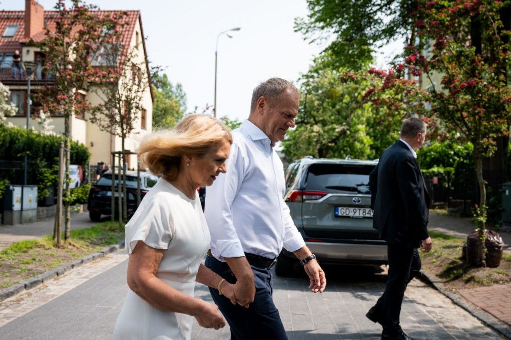 Poland's Prime Minister Donald Tusk (R) and his wife Malgorzata Tusk leave the polling station after they cast their ballots in Sopot, Poland, during the second round of the presidential elections on June 1, 2025. Polling stations opened for a tight presidential election runoff that will have major implications for the country's role in Europe, and for abortion and LGBTQ rights. Opinion polls have predicted an extremely close race with nationalist historian Karol Nawrocki and pro-EU Warsaw Mayor Rafal Trzaskowski neck and neck ahead of the vote. (Photo by MATEUSZ SLODKOWSKI / AFP)