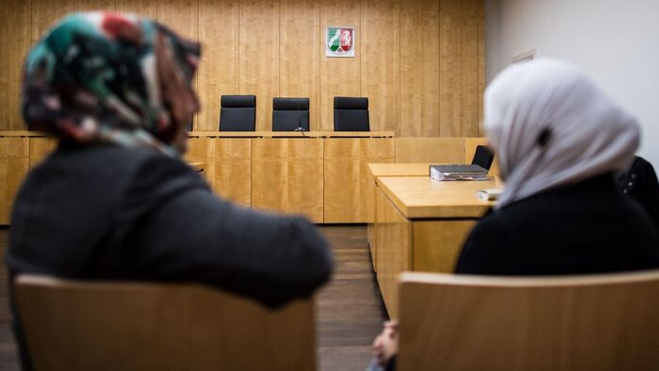 Two Muslim Council representatives sit in front of the higher administrative court in Muenster, Germany, November 9, 2017. (Photo by Guido Kirchner / dpa Picture-Alliance via AFP)