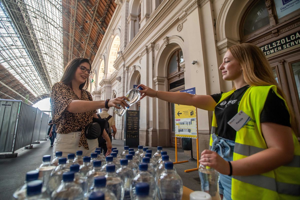 Ásványvizet ad egy utasnak a MÁV-START munkatársa a Keleti pályaudvaron (Fotó: MTI/Balogh Zoltán)