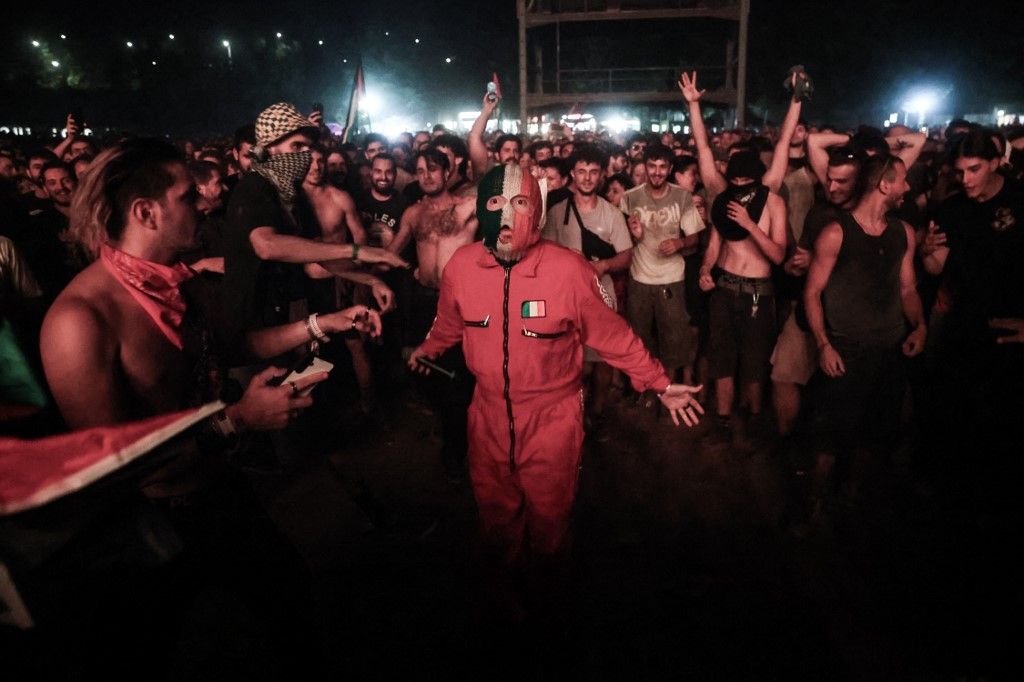 Member of Irish group Kneecap DJ Provai interacts with the audience during Rockwave Festival, in Athens, Greece, on July 13, 2025. The member of the group Mo Chara  was charged with a terror offence in May and appeared at Westminster Magistrates' Court earlier this month. (Photo by Dimitris Kapantais / SOOC via AFP)