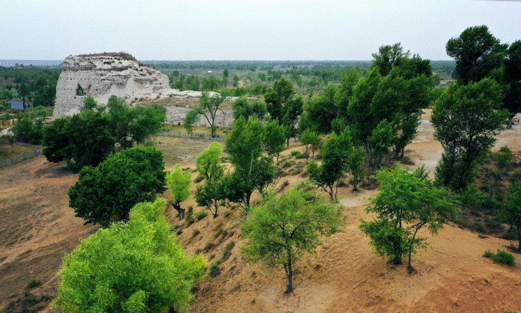 (200531) -- JINGBIAN, May 31, 2020 (Xinhua) -- Aerial photo taken on May 30 shows a view of Tongwancheng city ruins in Jingbian County, northwest China's Shaanxi Province. Shaanxi's Tongwancheng Town is the world's only ruins of the ancient Huns, also called the Xiongnu, an ancient Chinese nomadic tribe. The 1,600-year-old town is located in Jingbian County, some 500 kilometers away from the provincial capital Xi'an. It was one of the most complete and grand capitals ever built by a minority ethnic group in Chinese history. The city used to suffer from severe soil erosion and desertification, but after great efforts on desertification control, it has started to turn into a green historical site. (Xinhua/Liu Xiao) (Photo by Liu Xiao / Xinhua via AFP)