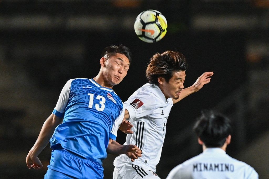 Japan's Hidemasa Morita (R) competes for the ball with Mongolias Ganbayar Ganbold during the FIFA World Cup Qatar 2022 Asian zone group F qualification football match between Japan and Mongolia at Fuku-ari stadium in Chiba on March 30, 2021. (Photo by CHARLY TRIBALLEAU / AFP)