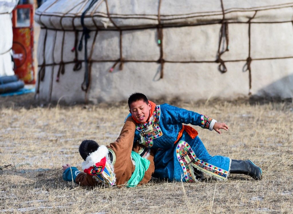 (170107) -- WEST UJIMQIN, Jan. 7, 2017 (Xinhua) -- Two Mongolian boys practice wrestling at a winter Nadam fair in West Ujimqin Banner, north China's Inner Mongolia Autonomous Region, Jan. 7, 2017. The 5-day event kicked off here on Saturday. Nadam Fair, meaning "entertainment" or "recreation" in Mongolian, is a mass traditional Mongolian festival mainly filled with sports events. (Xinhua/Lian Zhen) (wx) (Photo by Lian Zhen / Xinhua via AFP)