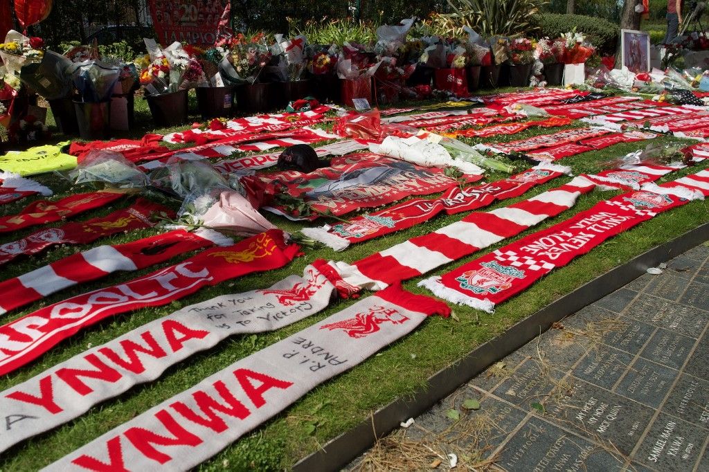 Szoboszlai Dominik, Kerkez Milos és Pécsi Ármin is lerótta a tiszteletét az Anfielden Diogo Jota és testvére előtt, Liverpool scarves are seen beside flowers left at a memorial set up close to Anfield football ground for their Portuguese forward Diogo Jota in Liverpool, north-west England July 3, 2025. Liverpool striker Diogo Jota died along with his brother early July 3, 2025 in a road accident in northwest Spain, the Spanish Civil Guard said. The accident occurred on a highway in the province of Zamora. The vehicle "left the road" before bursting into flames, the Civil Guard said, adding that the two passengers, Diogo Jota and his brother Andre Felipe, also a professional footballer, were deceased. (Photo by Paul BARKER / AFP)