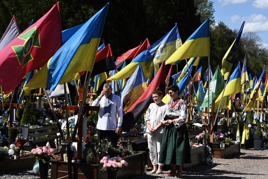 Egy család imádkozik egy elesett ukrán katona sírja előtt (Fotó: AFP)