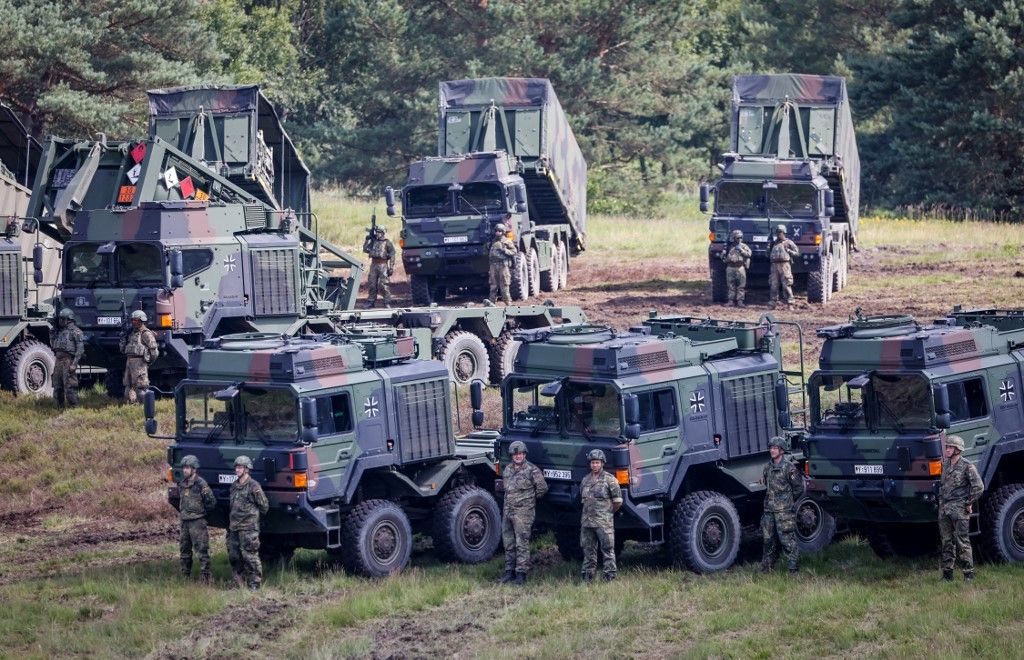 Soldiers of the German army stand in front of transport trucks during an excercise on the Tag der Bundeswehr (Bundeswehr Day) at the Bundeswehr Logistics School at Lucius D. Clay barracks in Garlstedt near Osterholz-Scharmbeck, Germany, on 28 June 2025. On Bundeswehr Day, the German armed forces demonstrate their capabilities to a wide audience at ten locations throughout Germany. (Photo by FOCKE STRANGMANN / AFP)