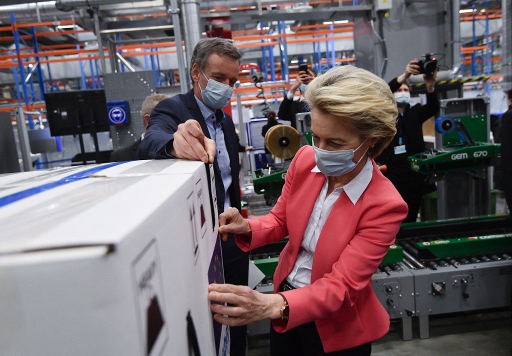 European Commission President Ursula von der Leyen sticks EU flag label during a visit at the factory of US pharmaceutical company Pfizer, in Puurs, on April 23, 2021. (Photo by JOHN THYS / POOL / AFP)