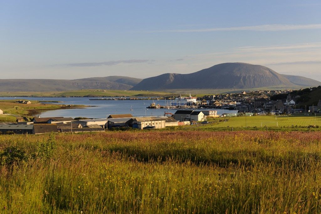 Az Orkney-szigeteki Stromness városa, a 2025-ös Szigetjátékok egyik legfontosabb helyszíne, United Kingdom, Scotland, Orkney Islands, Mainland Island, Stromness Harbour in front of Ward Hill on Hoy that is the highest hill in Orkney (Photo by RIEGER Bertrand / hemis.fr / Hemis via AFP)
