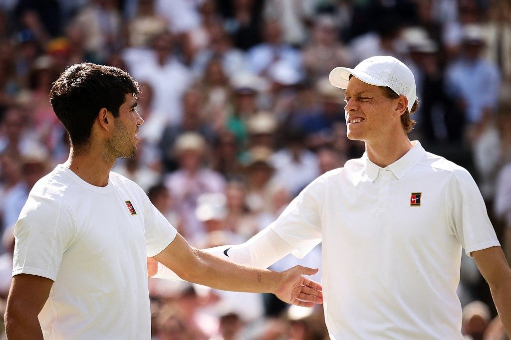 Italy's Jannik Sinner (R) winks at Spain's Carlos Alcaraz ahead of their men's singles final tennis match on the fourteenth day of the 2025 Wimbledon Championships at The All England Lawn Tennis and Croquet Club in Wimbledon, southwest London, on July 13, 2025. (Photo by HENRY NICHOLLS / AFP) / RESTRICTED TO EDITORIAL USE