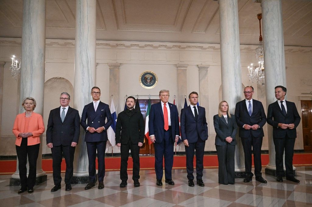(L/R) European Commission President Ursula von der Leyen, British Prime Minister Keir Starmer, Finnish President Alexander Stubb, Ukrainian President Volodymyr Zelensky, US President Donald Trump, French President Emmanuel Macron, Italian Prime Minister Giorgia Meloni, German Chancellor Friedrich Merz and NATO Secretary-General Mark Rutte pose for a family photo in the Cross Hall of the White House in Washington, DC, on August 18, 2025. European leaders join Ukrainian President Volodymyr Zelensky in talks with US President Donald Trump on August 18, as they try to find a way to end Russia's offensive. The leaders heading to Washington on Monday to appear alongside Zelensky call themselves the "coalition of the willing." (Photo by ANDREW CABALLERO-REYNOLDS / AFP)