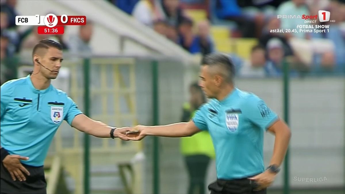 A román játékvezető átveszi a lapokat kollégájától, miután elhagyta a sajátjait