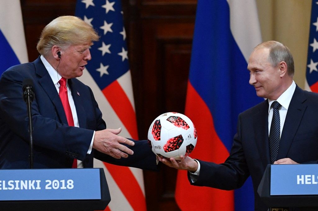 Russia's President Vladimir Putin (R) offers a ball of the 2018 football World Cup to US President Donald Trump during a joint press conference after a meeting at the Presidential Palace in Helsinki, on July 16, 2018. The US and Russian leaders opened an historic summit in Helsinki, with Donald Trump promising an "extraordinary relationship" and Vladimir Putin saying it was high time to thrash out disputes around the world. (Photo by Yuri KADOBNOV / AFP)