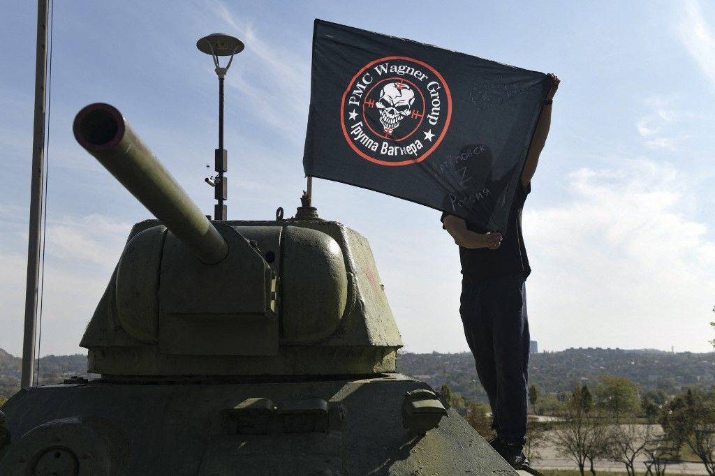 A man poses with a flag of Wagner group mounted on top of an old tank exhibited at the Leninist Komsomol park in Donetsk, Russian-controlled Ukraine, on October 1, 2023, to mark 40 days since the death of Wagner private mercenary group chief Yevgeny Prigozhin as per Orthodox tradition. Prigozhin, the head of the Wagner mercenary group, died with nine other people when a plane flying from Moscow to Saint Petersburg crashed on August 23. (Photo by AFP)