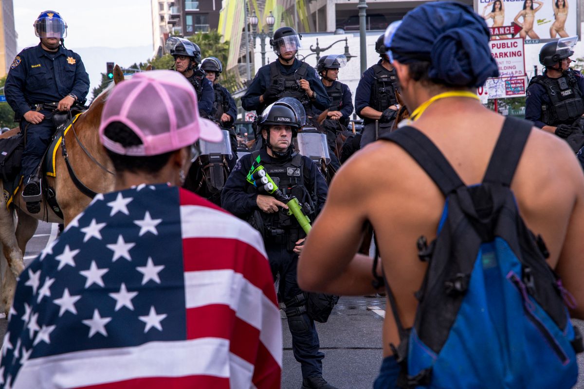 Policeman holds riot gun as people turn out for "No Kings" rally to protest ICE, Trump, and his policies in Los Angeles, California, on June 14, 2025. (Photo by Sahab Zaribaf / Middle East Images via AFP)