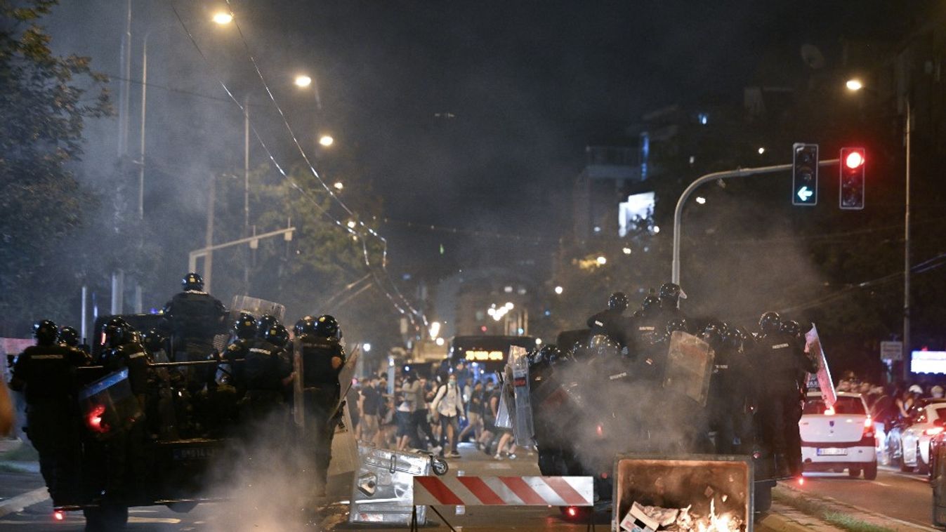 Szerb rohamrendőrök haladnak el az út mentén szétszórt égő szemetes konténerek mellett, miközben szembeszállnak a tüntetőkkel (Fotó: AFP)