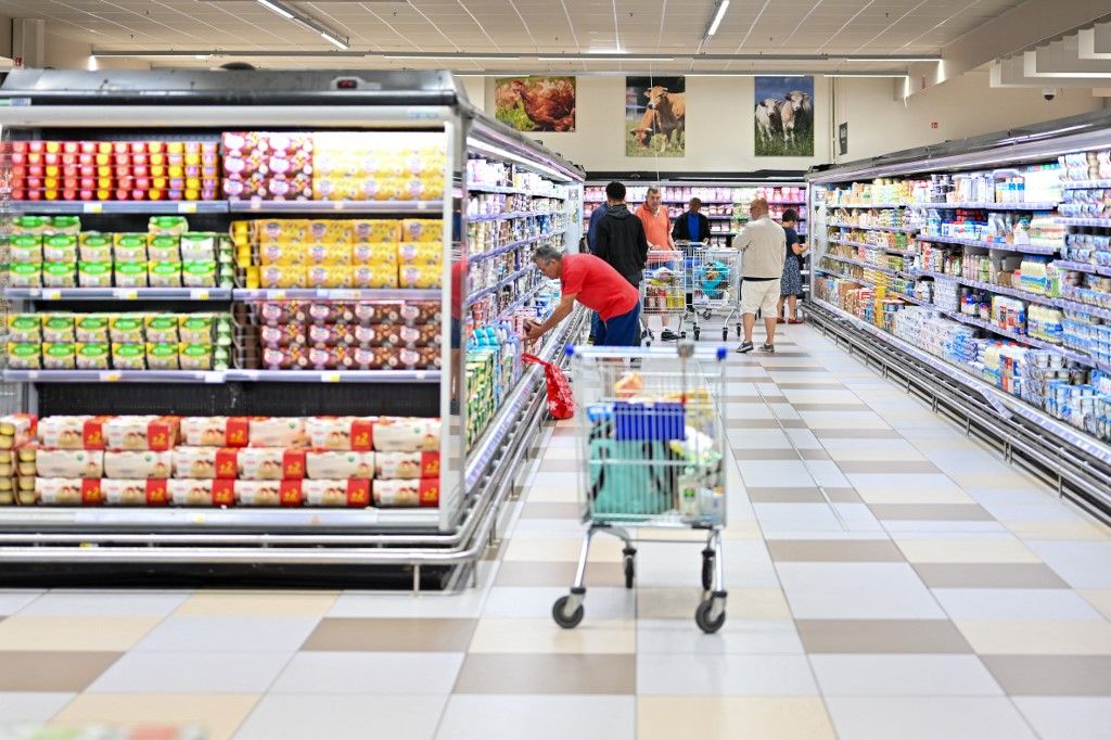 Európai Bizottság, View inside a Leclerc store, a shopping cart in the foreground and, in the background, people helping themselves to dairy products, in Bois d Arcy, France, on August 4, 2025. (Photo by Henrique Campos / Hans Lucas via AFP)