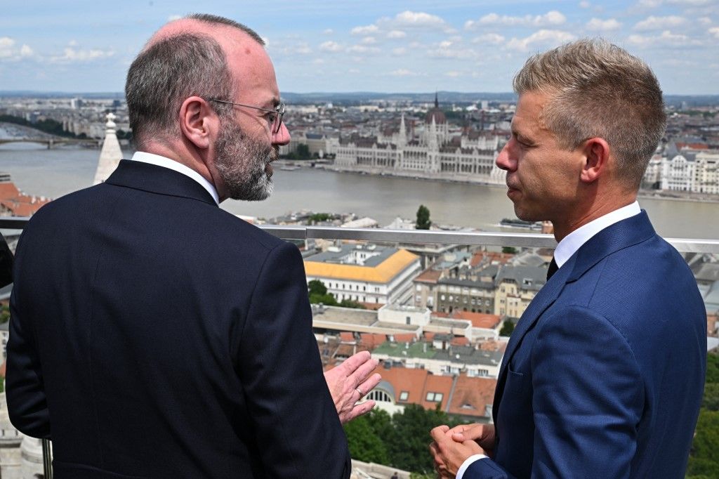 President of the centre-right European People's Party (EPP) Manfred Weber  (L) and leader of Hungarian Tisza party and former government member turned opposition leader Peter Magyar are pictured during a meeting on top of a Budapest's hotel in Hungary on June 14, 2024. Weber arrived to Budapest about the accession of the seven elected members of the European Parliament of the Tisza party. (Photo by Attila KISBENEDEK / AFP)