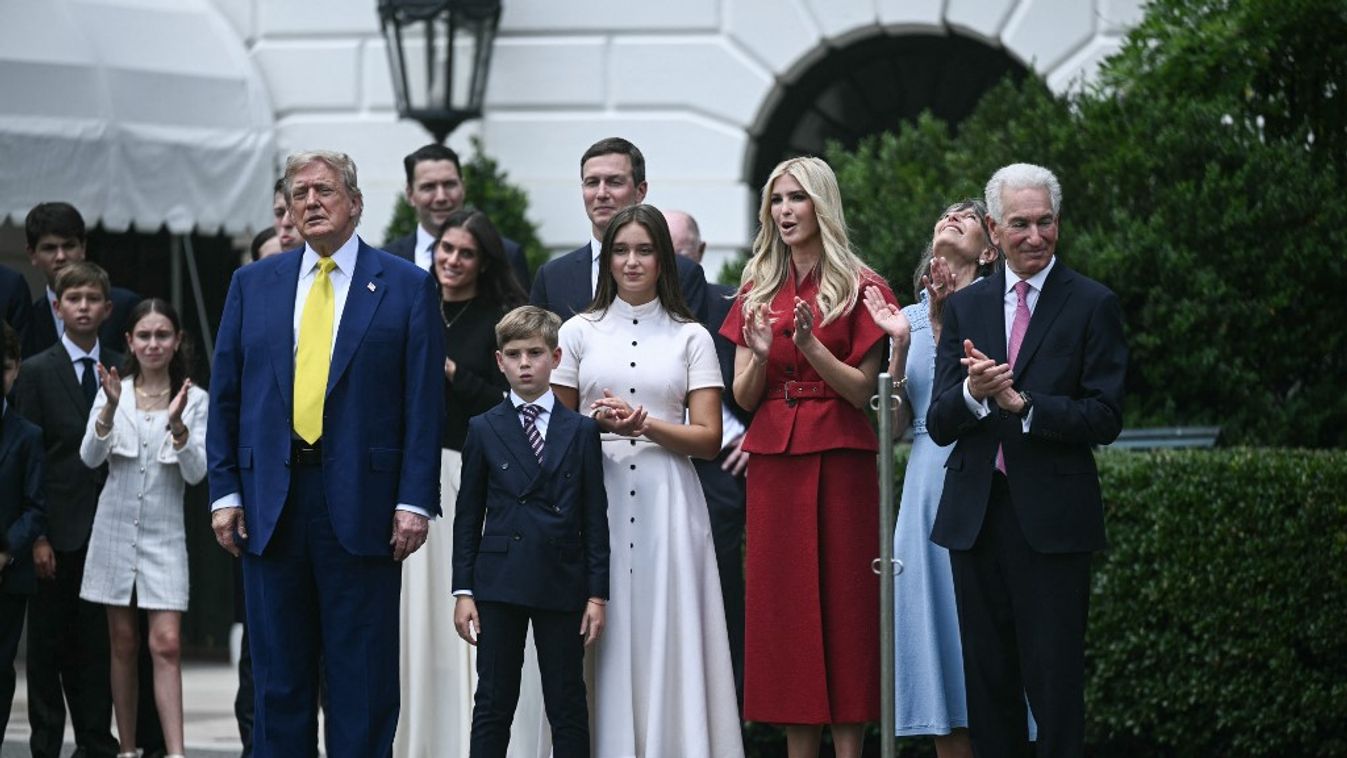 Donald Trump amerikai elnök és a franciaországi nagykövet, Charles Kushner (jobbra) nézik, ahogy az amerikai zászlót felhúzzák egy zászlórúdra a Fehér Ház déli pázsitján Washingtonban, 2025. június 18-án (Fotó: AFP)