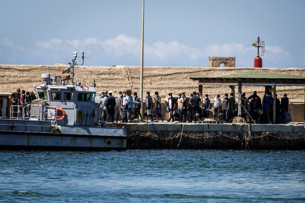 Migrants wait at a reception centre of the so-called migrant "Hotspot" operational processing facility on the southern Italian Pelagie Island of Lampedusa, south of Sicily, before being transferred to another center, on July 11, 2022. (Photo by Alessandro SERRANO / AFP)