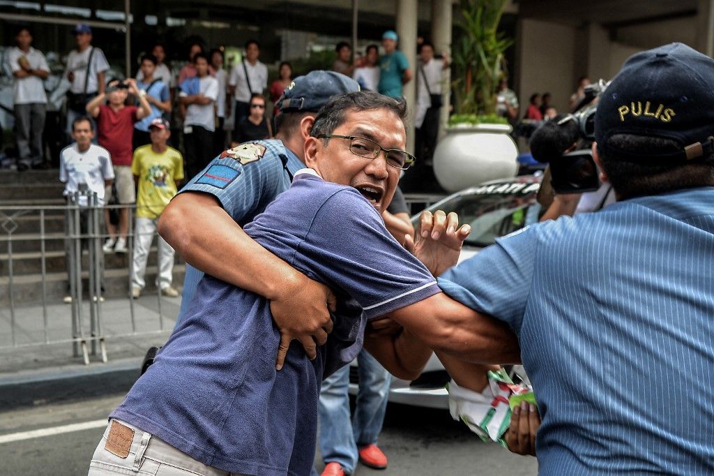 Policemen attempt to arrest former congressman and activist Teddy Casino during a protest near the venue of the World Economic Forum on East Asia at the financial district of Makati, south of Manila, Philippines, May 22, 2014. Demonstrators criticized the Philippine government for allegedly hiding the worsening poverty and rampant corruption in the country as it welcomes foreign leaders and business heads during Asia's version of the World Economic Forum.

Photo: Ezra Acayan/NurPhoto (Photo by Ezra Acayan / NurPhoto via AFP)