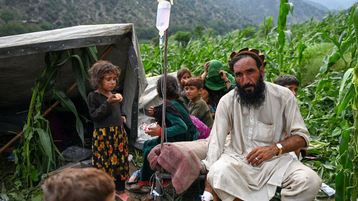 EDITORS NOTE: Graphic content / An Afghan injured man receives intravenous drips in a corn field, after earthquakes at Mazar Dara village in Nurgal district, Kunar province, in Eastern Afghanistan, on September 1, 2025. More than 800 people have died and over 2,700 were injured from August 31 night to September 1, 2025, in eastern Afghanistan after a 6-magnitude earthquake, followed by at least five aftershocks felt hundreds of kilometers away. (Photo by Wakil Kohsar / AFP)