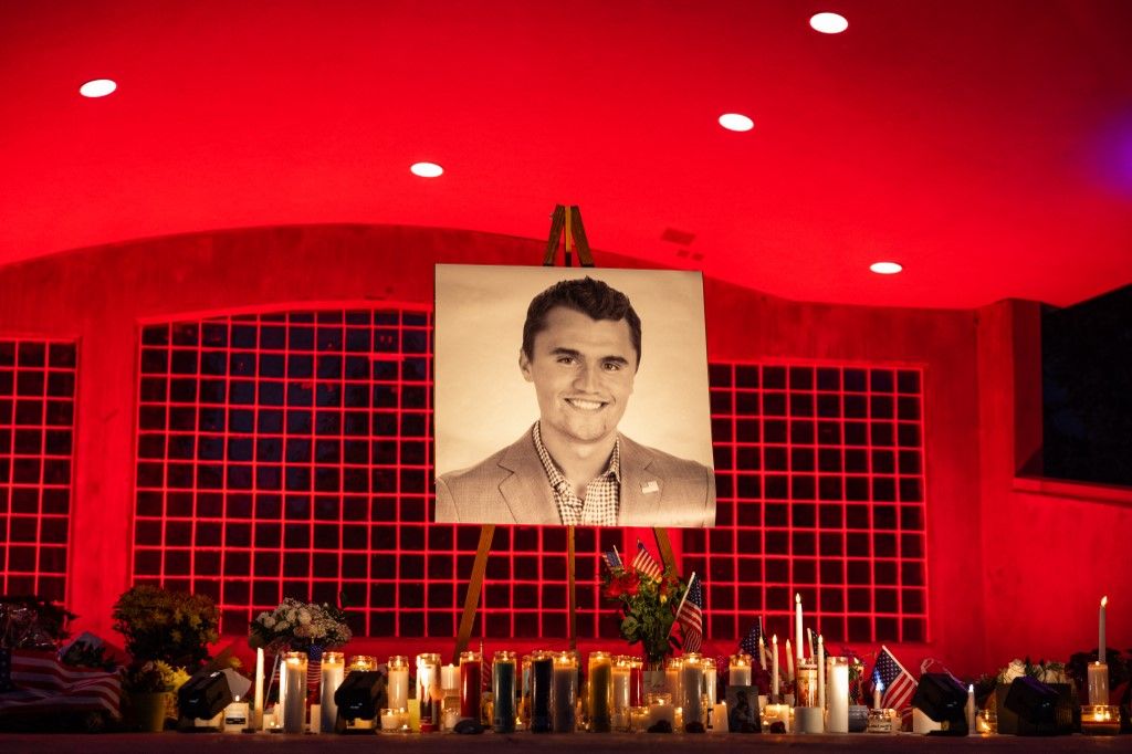 A photo of youth activist and influencer Charlie Kirk is seen at his makeshift memorial at Orem City Center Park in Orem, Utah, a day after he was shot during a public event at Utah Valley University on September 11, 2025. The gunman who shot dead US right-wing youth leader Charlie Kirk in a targeted killing remained at large Thursday but authorities said they have video images of the suspect and have recovered a "high-powered" rifle. Kirk, a 31-year-old superstar on the Republican right who was credited with helping Donald Trump return to the presidency last year, was shot while addressing a large crowd at Utah Valley University on Wednesday. (Photo by Melissa MAJCHRZAK / AFP)