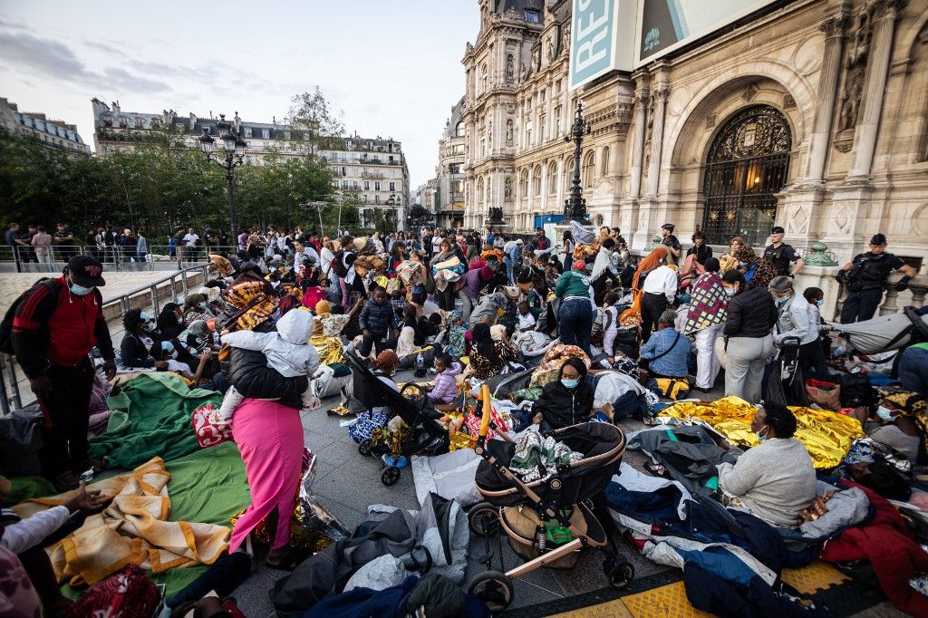 Around 200 homeless migrants, including 80 children, spend the night in front of the Hotel de Ville in Paris, France, on August 5, 2025, due to a lack of emergency accommodation. With the support of the Utopia 56 Association, the migrants, mostly women and children, gather in protest to demand housing solutions from the Paris City Hall and intend to remain in front of City Hall until concrete solutions are found. Several volunteers support the action by distributing sleeping bags, blankets, water, and some food. (Photo by Telmo Pinto/NurPhoto) (Photo by Telmo Pinto / NurPhoto via AFP)
