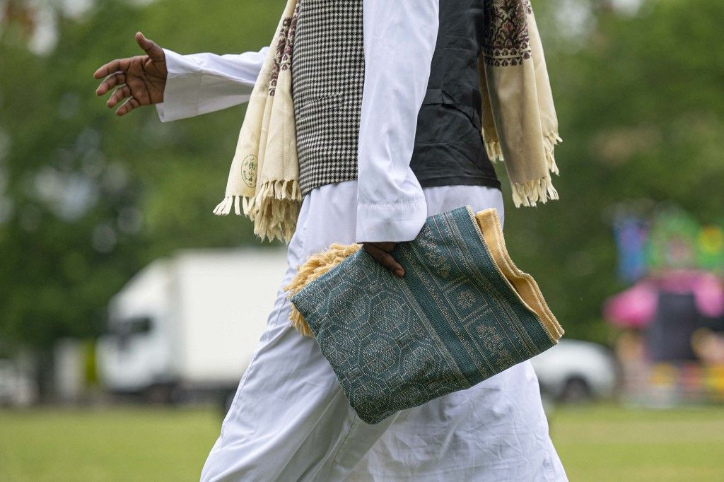 LONDON, UNTED KINGDOM - JUNE 28: A man holds a prayer rug as the Muslims celebrate the Eid al-Adha at the Highbury Park in London, United Kingdom on June 28, 2023. Rasid Necati Aslim / Anadolu Agency (Photo by Rasid Necati Aslim / ANADOLU AGENCY / Anadolu via AFP)