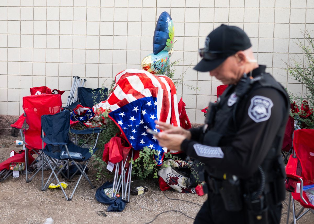 A police officer passes discarded chairs and trash outside the memorial for Charlie Kirk at State Farm Stadium in Glendale, Arizona, on September 21, 2025. (Photo by ANDREW CABALLERO-REYNOLDS / AFP)