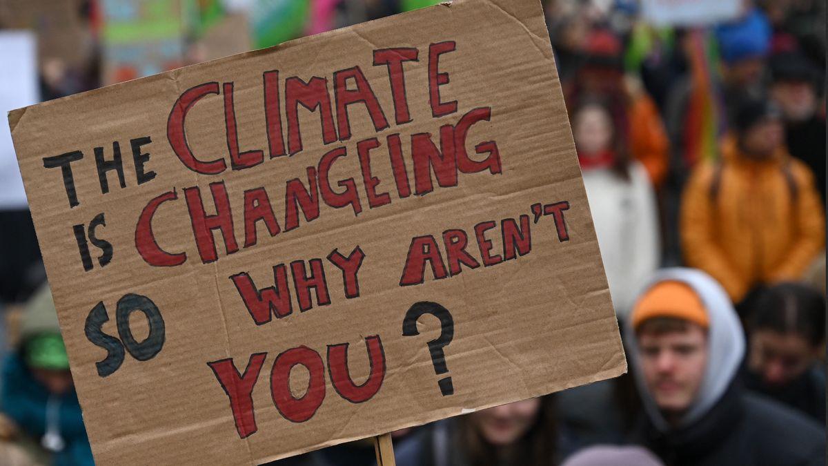 A supporter of the environmental Fridays for Future movement holds up a poster reading "The climate is changeing - so why aren't you?" during a demonstration for climate action on March 3, 2023 in Munich, southern Germany. The Fridays for Future movement joined with the verdi union representing interests in the service sector to call a global climate strike as well as a strike in the public sector. (Photo by Christof Stache / AFP)