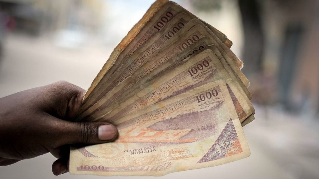 A handout photo taken on October 23, 2013 and released on October 25 by the African Union-United Nations Information Support Team shows a man holding Somali shilling notes after having exchanged US dollars with a money changer in Mogadishu. Millions of people in Somalia rely on money sent from relatives and friends abroad in the form of remittances to survive, but it is feared that a decision by Barclays Bank to close the accounts of some of the biggest Somali money transfer firms - due to be announced this week -- will have a devastating effect on the country and its people. According to the United Nations Development Programme (UNDP), an estimated 1.6 billion US dollars is sent back annually by Somalis living in Europe and North America. Some money transfer companies in Somalia have been accused of being used by pirates to launder money received from ransoms as well as used by the Al-Qaeda-linked Shebab group to fund terrorist activities and operations in Somalia and the wider East African region.               AFP PHOTO / AU-UN IST PHOTO / STUART PRICE
RESTRICTED TO EDITORIAL USE - MANDATORY CREDIT "AFP PHOTO / AU-UN IST PHOTO / STUART PRICE" - NO MARKETING NO ADVERTISING CAMPAIGNS - DISTRIBUTED AS A SERVICE TO CLIENTS (Photo by STUART PRICE / AU-UN IST PHOTO / AFP)