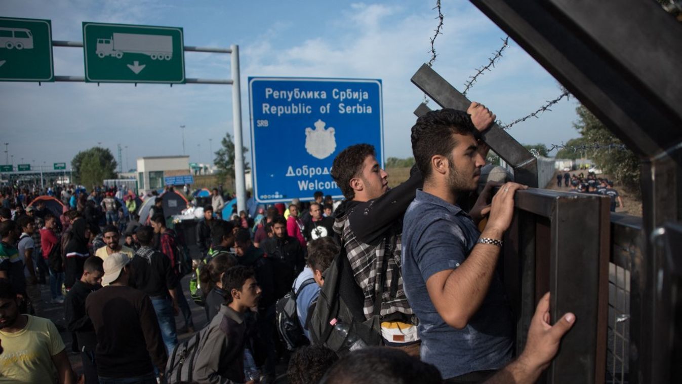 Migránsok támadják a határkerítést (Fotó: AFP)