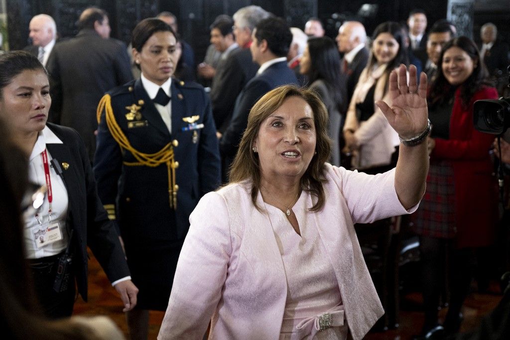 Peru's President Dina Boluarte waves to the press after a ceremony enacting an amnesty law for military and police personnel prosecuted for human rights violations at the Government Palace in Lima on August 13, 2025. Peruvian President Dina Boluarte on Wednesday enacted a controversial amnesty law for military and police personnel prosecuted for human rights violations during the armed conflict that ravaged the country between 1980 and 2000. (Photo by Ernesto BENAVIDES / AFP)