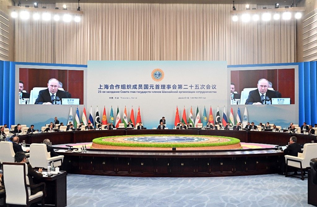 In this pool photograph distributed by the Russian state agency Sputnik, Russia's President Vladimir Putin (on screens) attends the Shanghai Cooperation Organisation (SCO) Summit in Tianjin on September 1, 2025. (Photo by Sergey Bobylev / POOL / AFP)