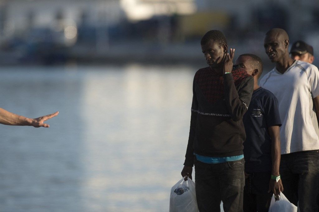 Migrants queue as they are transferred upon their arrival aboard a coast guard boat at Malaga's harbour on September 21, 2018, after an inflatable boat carrying 121 immigrants was rescued off the Spanish coast. (Photo by JORGE GUERRERO / AFP)