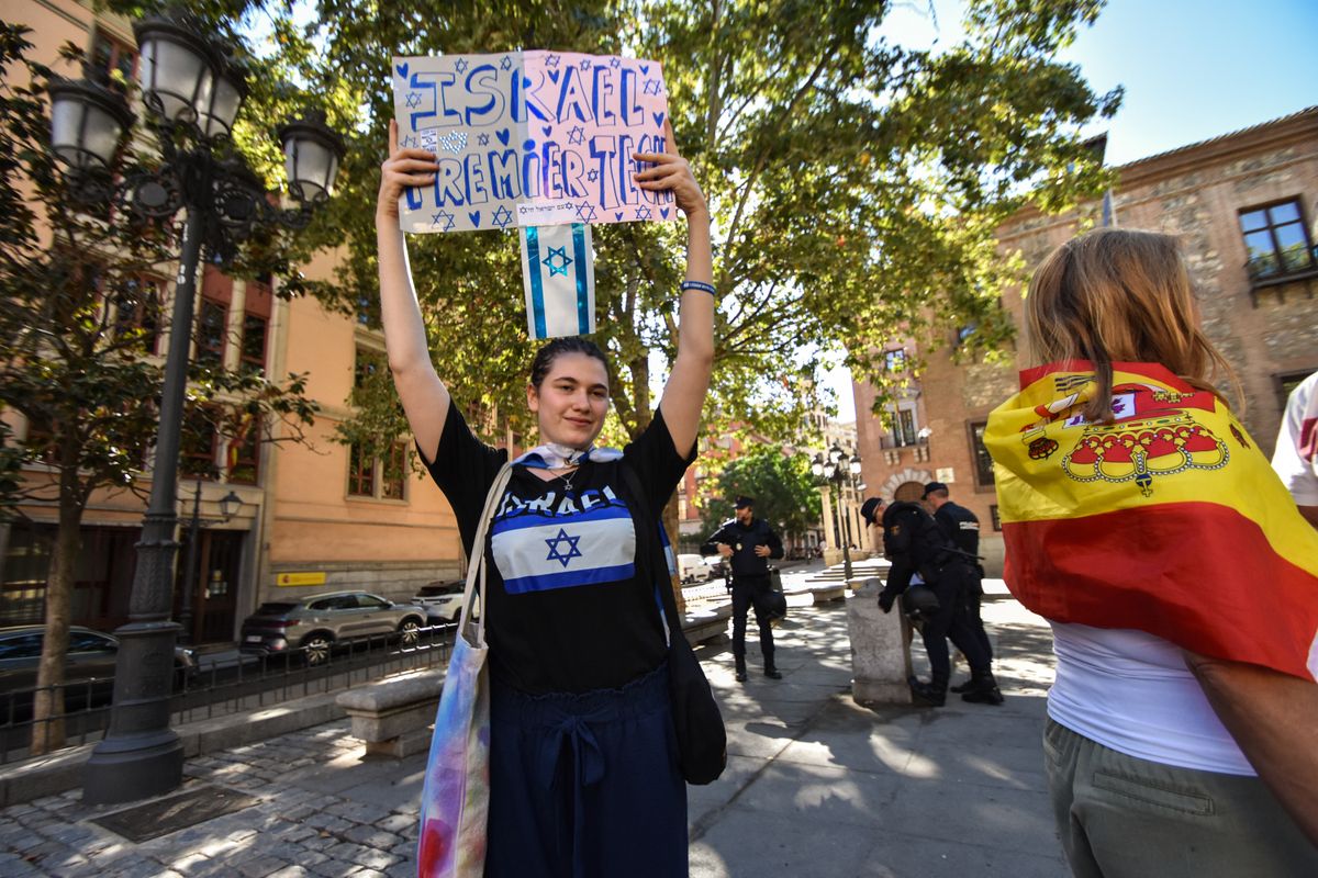 On September 14, 2025, in Madrid, Spain, the Vuelta a Espana comes to an unprecedented halt as the final stage is canceled with 56 km to go due to large-scale pro-Palestinian protests in the heart of the Spanish capital. Despite a massive deployment of around 1,500 officers, demonstrators break through police barriers at Cibeles, chant ''Free Palestine,'' and block the race circuit. For security reasons, several pro-Israel sympathizers are escorted away from the area by Policia Nacional to prevent direct clashes. (Photo by Francesco Militello Mirto/NurPhoto) (Photo by Francesco Militello Mirto / NurPhoto via AFP)