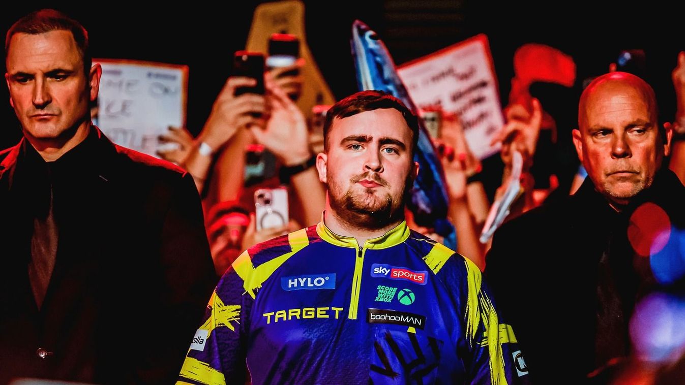 Luke Littler a biztonsági őrök gyűrűjében Budapesten