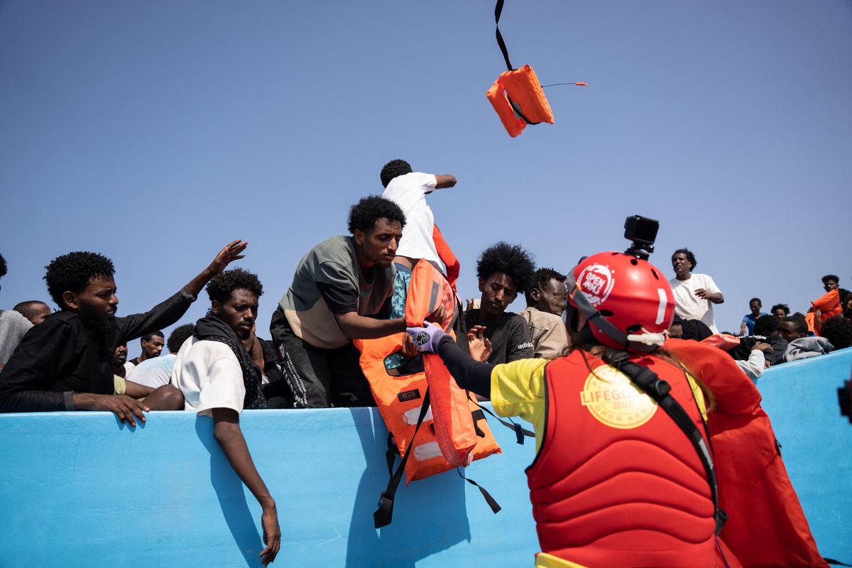 CENTRAL MEDITERRANEAN - AUGUST 26: A boat carrying 130 migrants, including 18 women and 6 girls, from Egypt, Eritrea, and Sudan, departed from Libya at 4:00 a.m. on August 26, 2025, attempting to reach Europe. After a fishing vessel alerted about their position, the rescue ship Astral, operated by the NGO Open Arms, approached to distribute life jackets and water to those on board. Later, the Italian Coast Guard arrived and transferred all the passengers to safety. Joan Galvez / Anadolu (Photo by Joan Galvez / Anadolu via AFP)