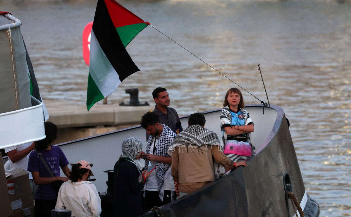 (FILES) Swedish climate activist Greta Thunberg (R) is seen on board of a vessel of a civilian flotilla, carrying pro-Palestinian activists, and humanitarian aid and aiming to break the Israeli blockade of the Gaza Strip, remains moored at Barcelona port on September 1, 2025, after being forced to return due to bad weather. Spain is to send navy ship to assist Gaza aid flotilla, AFP reports on September 24, 2025. (Photo by Lluis GENE / AFP)
