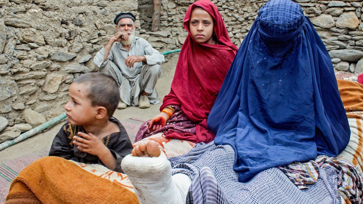 An Afghan burqa-clad woman with an injured leg sits beside children outside a house, in the aftermath of an earthquake at the Dara-i-Nur district of Nangarhar province on September 3, 2025. Hope was quickly fading of finding survivors in the rubble of homes devastated by the weekend's powerful 6.0-magnitude quake in eastern Afghanistan, as emergency services struggled to reach remote villages on September 3. (Photo by AFP)