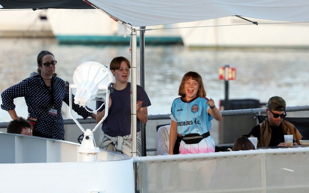 Swedish climate activist Greta Thunberg (2R) is seen aboard of a vessel of a civilian flotilla, carrying pro-Palestinian activists and humanitarian aid and aiming to break the Israeli blockade of the Gaza Strip, remains moored at Barcelona port on September 1, 2025, after being forced to return due to bad weather. Fierce Mediterranean winds forced back to Barcelona a Gaza-bound flotilla carrying humanitarian aid and hundreds of pro-Palestinian activists including environmental campaigner Greta Thunberg, organisers said today. Some 20 vessels left Barcelona yesterday aiming to "open a humanitarian corridor and end the ongoing genocide of the Palestinian people" amid the Israel-Hamas war, said the Global Sumud Flotilla -- sumud being the Arabic term for "resilience". (Photo by Lluis GENE / AFP)