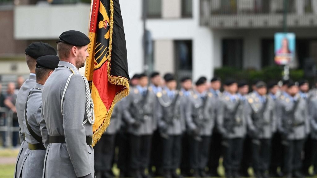 Soldiers with the German flag, soldiers of the honor guard lined up in the background, solemn oath of allegiance of Bundeswehr recruits in front of the state parliament in Duesseldorf, 04.10.2024, (Photo by Malte Ossowski/SVEN SIMON / SvenSimon / dpa Picture-Alliance via AFP)