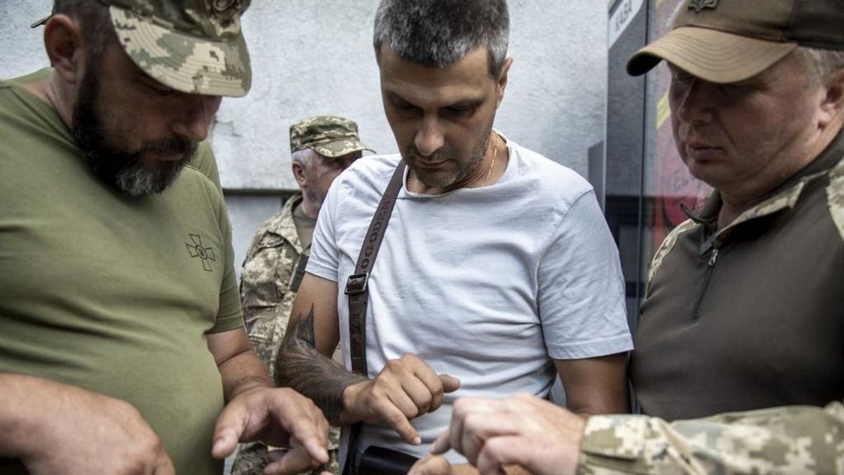 Kényszersorozás – A Harkivi Regionális Toborzó Iroda (TCK) tagjai egy civil férfi papírjait ellenőrzik