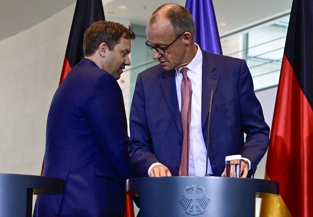 German Chancellor Friedrich Merz (R) and German Finance Minister and Vice Chancellor Lars Klingbeil arrive for a press conference following a meeting on the future of the German automotive industry at the Chancellery on October 9, 2025. (Photo by John MACDOUGALL / AFP)
